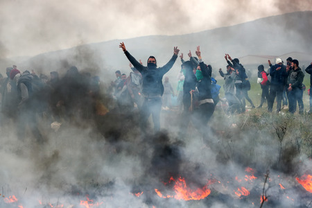 Thessaloniki, Greece - April 5, 2019: Migrants clashes with Greek riot police outside of a refugee...