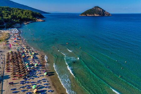 Aerial View of the Paradise Beach with colorful umbrellas, at Thassos island, Greece. swimming people in seaの写真素材
