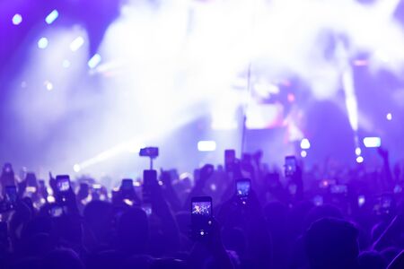People taking photographs with touch smart phone during a music entertainment public concert.  live concert, music festival, happy youth, luxury party, landscape exterior. Selctive Focusの写真素材
