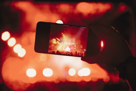People taking photographs with touch smart phone during a music entertainment public concert.  live concert, music festival, happy youth, luxury party, landscape exterior. Selctive Focusの写真素材