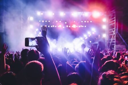 People taking photographs with touch smart phone during a music entertainment public concert.  live...