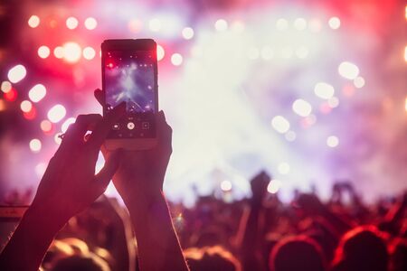 People taking photographs with touch smart phone during a music entertainment public concert.  live concert, music festival, happy youth, luxury party, landscape exterior. Selctive Focusの写真素材