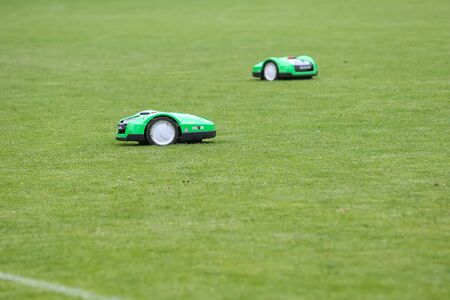 Oosterbeek, Netherlands - July 11, 2018: Automatic robotic lawnmower on green grass in the stadium. Mowing the lawn with a robot.のeditorial素材