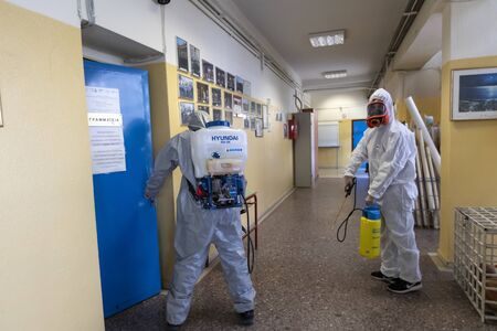 Thessaloniki, Greece - Feb 28, 2020: Workers sprays disinfectant as part of preventive measures against the spread of the COVID-19, the novel coronavirus, in a schoolのeditorial素材