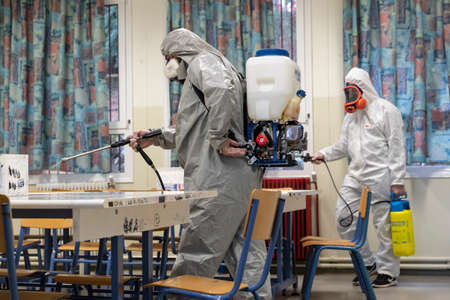 Thessaloniki, Greece - Feb 28, 2020: Workers sprays disinfectant as part of preventive measures against the spread of the COVID-19, the novel coronavirus, in a schoolのeditorial素材