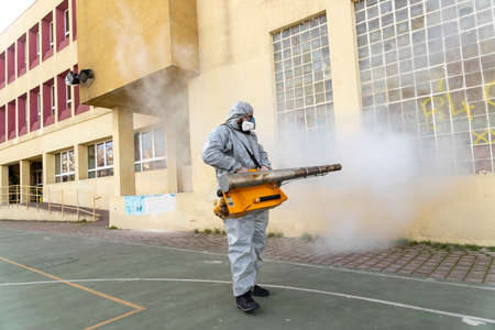 Thessaloniki, Greece - Feb 28, 2020: Workers sprays disinfectant as part of preventive measures against the spread of the COVID-19, the novel coronavirus, in a schoolのeditorial素材