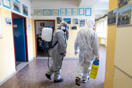 Thessaloniki, Greece - Feb 28, 2020: Workers sprays disinfectant as part of preventive measures against the spread of the COVID-19, the novel coronavirus, in a schoolのeditorial素材