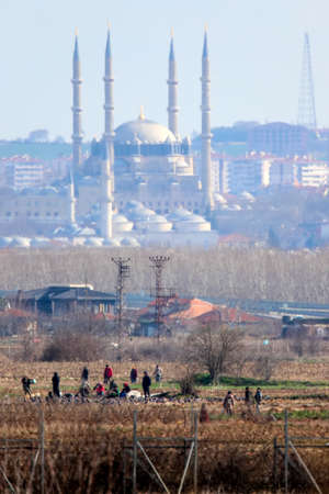 Kastanies, Evros, Greece - March 2, 2020: Greek police and soldiers in front of a fence trying to deter migrants as they attempt to enter Greece from Turkey at the Greek-Turkish border in Kastaniesのeditorial素材