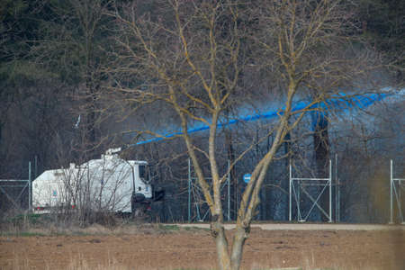 Kastanies, Evros, Greece - March 1, 2020: Greek police vehicle pours paint on migrants as they attempt to enter Greece from Turkey at the Greek-Turkish border in Kastaniesのeditorial素材