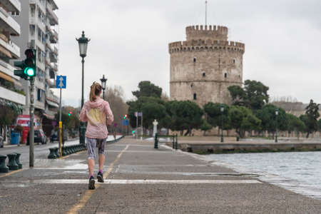 Thessaloniki, Greece - March 23, 2020: A woman jogging at Thessaloniki's port during lock down imposed by the government to prevent the further spread of the coronavirusのeditorial素材
