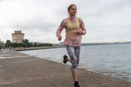 Thessaloniki, Greece - March 23, 2020: A woman jogging at Thessaloniki's port during lock down...