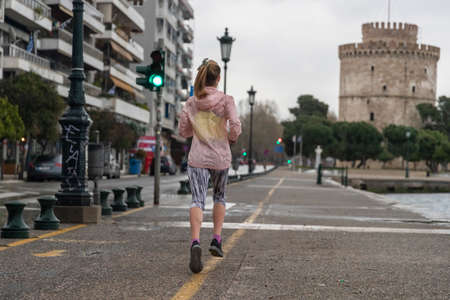 Thessaloniki, Greece - March 23, 2020: A woman jogging at Thessaloniki's port during lock down imposed by the government to prevent the further spread of the coronavirusのeditorial素材