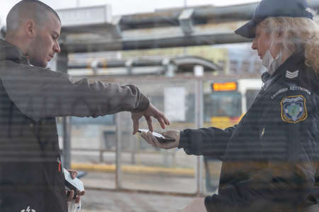 Thessaloniki, Greece - March 23, 2020: A police officer checks the documents of a citizen, as the country struggles to control the spread of the COVID-19, the novel coronavirus.のeditorial素材