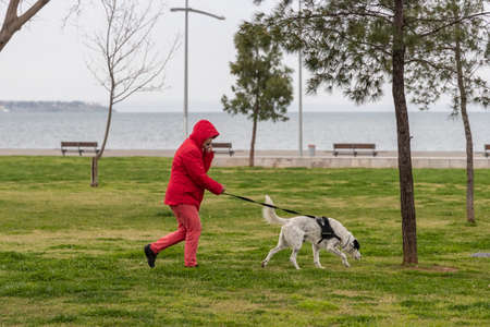Thessaloniki, Greece - March 23, 2020: a woman with her dog at the park at Thessaloniki's during lock down imposed by the government to prevent the further spread of the coronavirusのeditorial素材