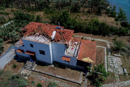 Nea Plagia, Chalkidiki, Greece - July 10, 2019: aerial photography of the damaged roofs of houses in...