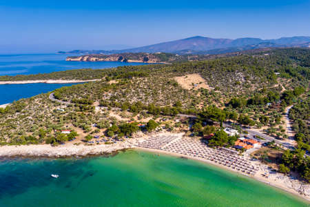 View from above, aerial view of an emerald and transparent Mediterranean sea with a white beach full of beach umbrellas and tourists who relax and swim. Psili Ammos, Thassos island, Greece.の写真素材