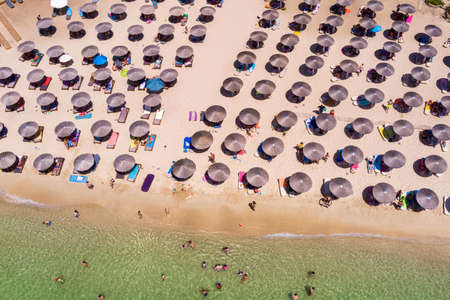 Psili Ammos, Thassos island, Greece - July 17, 2021:  View from above, aerial view of an emerald and transparent Mediterranean sea with a white beach full of beach umbrellas and tourists who relax and swim.のeditorial素材