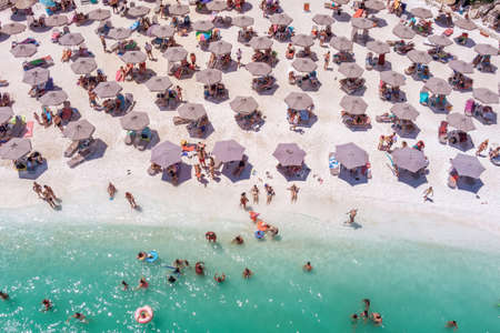 Marble beach, Thassos island, Greece- July 19, 2021: View from above, aerial view of an emerald and transparent Mediterranean sea with a white beach full of beach umbrellas and tourists who relax and swim.のeditorial素材