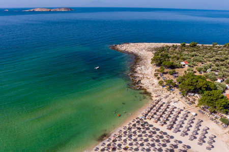 View from above, aerial view of an emerald and transparent Mediterranean sea with a white beach full of beach umbrellas and tourists who relax and swim. Psili Ammos, Thassos island, Greece.の写真素材