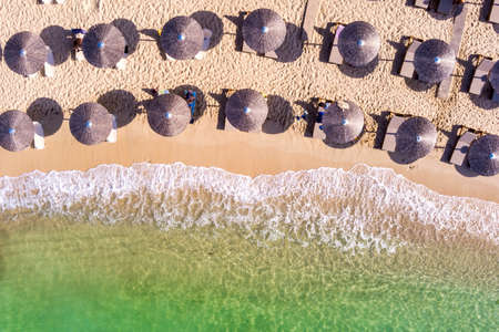 View from above, aerial view of an emerald and transparent Mediterranean sea with a white beach full of beach umbrellas and tourists who relax and swim. Psili Ammos, Thassos island, Greece.の写真素材