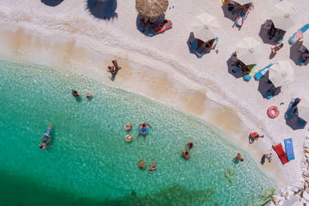 Porto Vathy, Marble Beach, Thassos, Greece- July 19, 2021: aerial view of the Porto Vathy beach of an emerald and transparent Mediterranean sea with a white beach full of beach umbrellas and tourists who relax and swimのeditorial素材