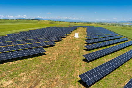 Aerial view photovoltaic panels park on green field in north Greece. Blue sky reflecting in solar panels rows. Futuristic alternative power station. Sustainable energy source. Renewable electricity technologyの写真素材