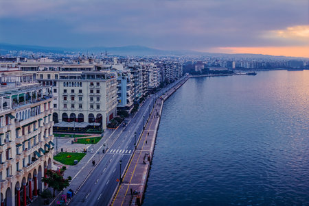 Dark clouds loom over Thessalonikiâ€™s waterfront as morning light breaks through. The White...