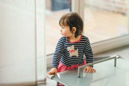 household safety of the children. girl standing at the table with the protection on the cornersの写真素材