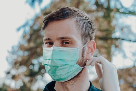 man wearing face mask and gloves to prevention of contamination, close up, outdoorの写真素材