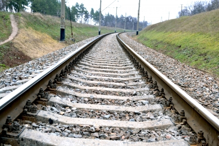 The photo shows the railroad with mound and the high voltage line. の写真素材