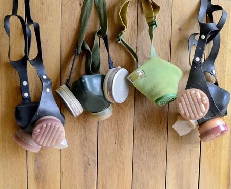 Photo of several old-style respirators on a wooden wall backgroundの写真素材