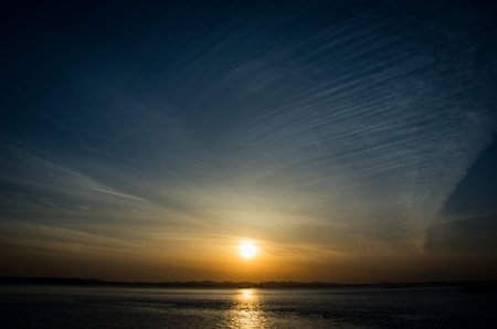 Beautiful sunset over the sea with clouds and rays of light.の写真素材