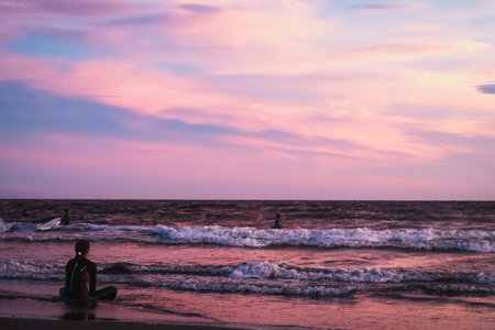 Surfer on the beach in the evening. Sunset at sea.の写真素材