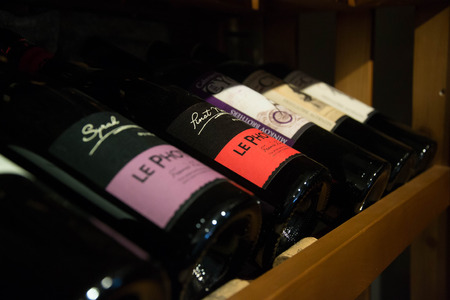 Bottles of wine in the cellar, restaurant, elite drinks on shelves with written names