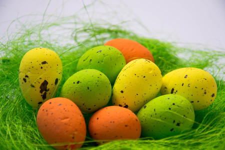 Green nest with colorful Easter eggs decoration on light purple background. Easter concept, holiday traditionの写真素材