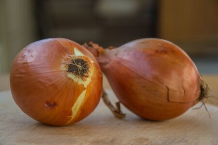 Close-up of two brown onions on wooden table, kitchen, healthy food, vegetarianの写真素材