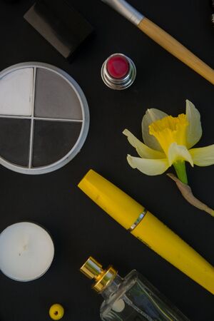 Beautiful yellow daffodils and set of decorative cosmetics, brushes and lipstick, jewelry, perfume,...