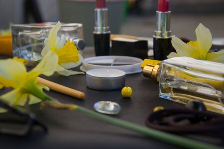 Beautiful yellow daffodils and set of decorative cosmetics, brushes and lipstick, jewelry, perfume, make up and girly stuff, selective focusの写真素材