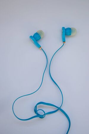 Close-up of isolated blue earphones, purple background, technologyの写真素材