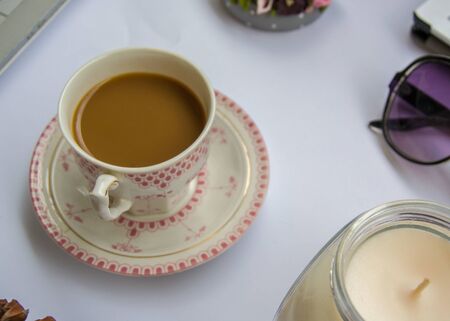 Coffee in the office, close-up of the desk with different objects, beautiful decorated cup with hot...