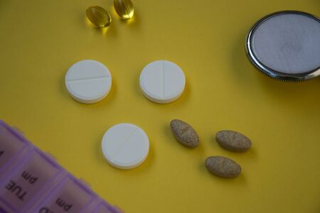 Bunch of pills and capsules, box for storage of drugs and medical stethoscope and blood pressure...