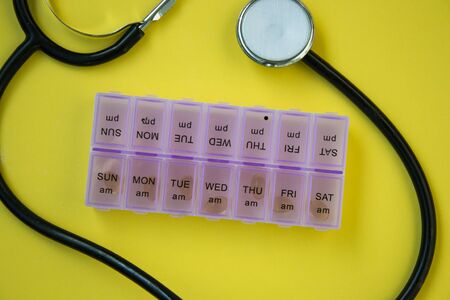 Medical stethoscope and blood pressure meter with container for pills for each day of the week,...