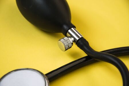 Medical stethoscope and blood pressure meter, yellow background, healthcare conceptの写真素材