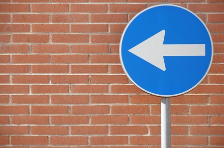 One way heading to left on wall backgroundの写真素材