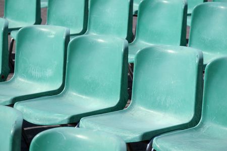 Weathered bleachers plastic seats in a stadiumの写真素材