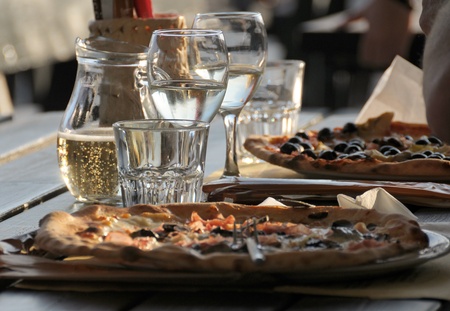 Pizza and wine in an outdoor restaurantの写真素材