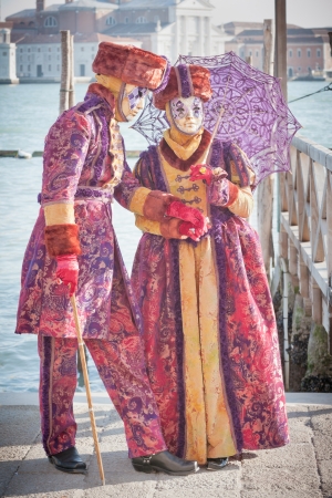 Venice, Italy - February 17, 2012: Couple of masks posing along Saint Mark waterfront during famous Venetian Carnival celebrations. Shot in Venice, Italyのeditorial素材