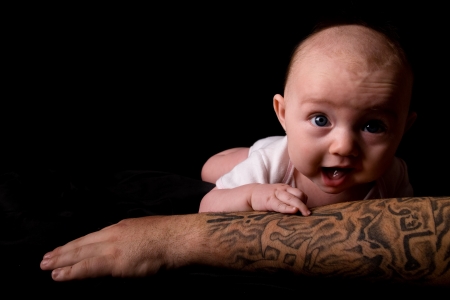 Baby Lying on Tattooed Armの写真素材