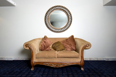 Couch and Mirror Against Wallの写真素材