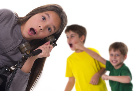 shocked girl reporting a fight between boys の写真素材